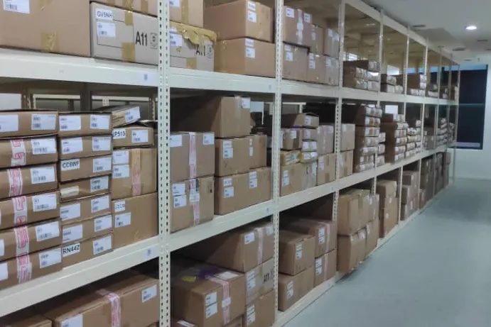 A long aisle of labelled boxes on warehouse racking