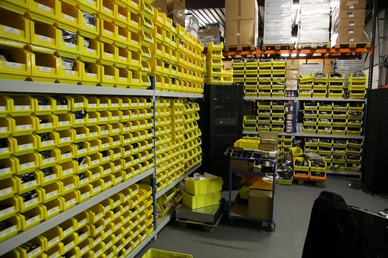 A hall of yellow parts bins on racking
